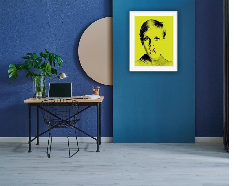 The Drugs Don't Work print, medium size, framed above a desk with a wire chair for scale